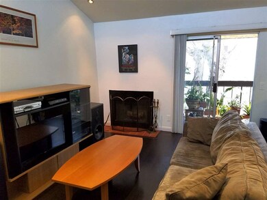 Vaulted ceiling and wood-burning fireplace in livi