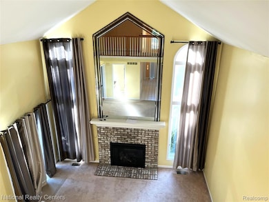 Unfurnished living room with a brick fireplace, carpet floors, and plenty of natural light