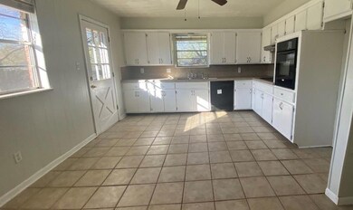 Kitchen featuring white cabinets, tasteful backspl