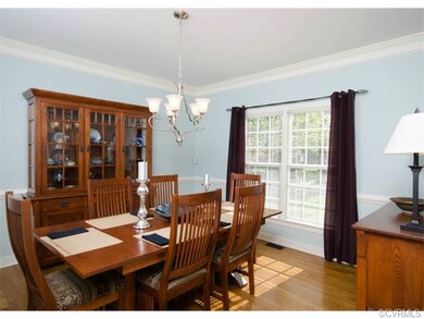 The formal dining room has hardwood floors, crown 