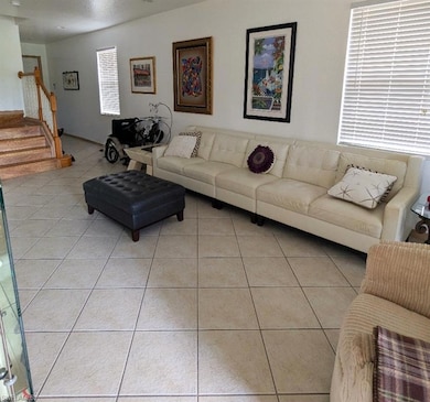 Living room with light tile patterned flooring and stairs