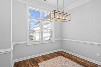 Unfurnished dining area with crown molding, dark h