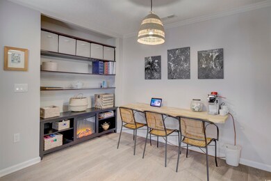 Office area with crown molding and light hardwood 