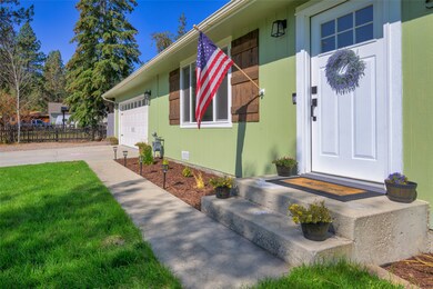 Doorway to property with concrete driveway and a garage