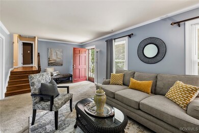 Carpeted living room featuring crown molding