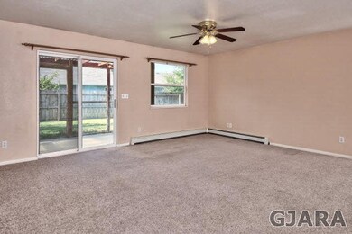 The spacious living room is carpeted and leads to 