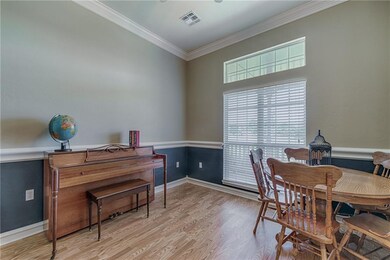 Office with crown molding and chair rail; laminate floors