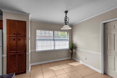 Eat in kitchen featuring ornamental molding and li