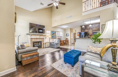 Living room featuring a tiled fireplace, ceiling f