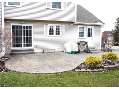 back of home with large stamped patio & sliders to