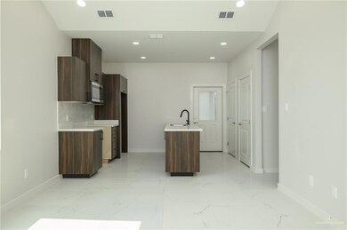 Kitchen with stainless steel microwave, baseboards, modern cabinets, light countertops, and recessed lighting
