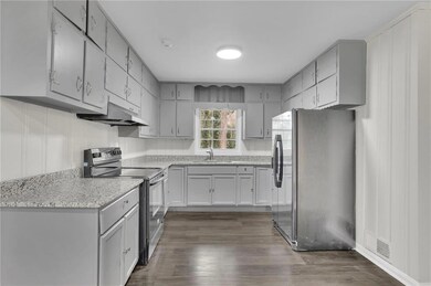 Kitchen featuring gray cabinets, a sink, appliance