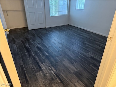 Unfurnished bedroom featuring dark wood-style floo