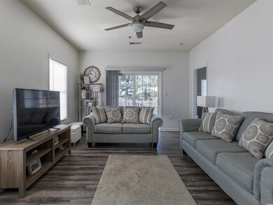 Living room featuring dark hardwood / wood-style flooring, a textured ceiling, and ceiling fan