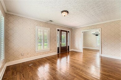 Spare room featuring crown molding, wood finished floors, and a textured ceiling