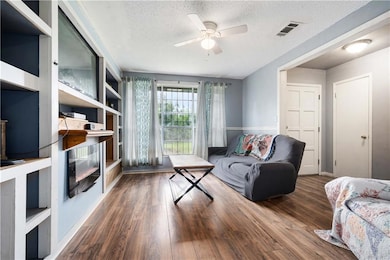 Living area featuring ceiling fan, a textured ceil