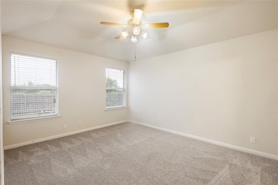 Carpeted spare room featuring ceiling fan and lof