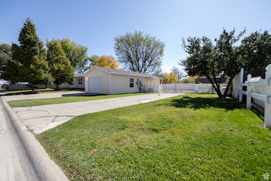 View of yard with concrete driveway and a garage