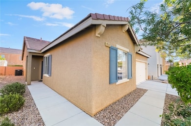 View of side of property with stucco siding and a tiled roof