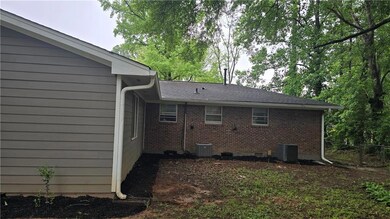 Rear view of house featuring central AC unit, brick siding, and crawl space