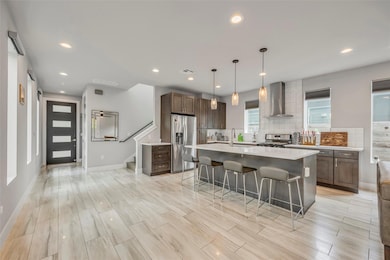 Kitchen featuring wall chimney range hood, visibl
