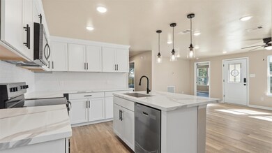 View from the kitchen looking into the bright and open living space, highlighting the stunning natural light and elegant quartz countertops.
