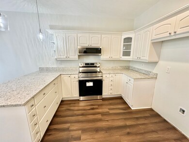 Kitchen with dark wood-type flooring, appliances w
