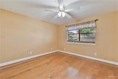 Empty room with wood finished floors and a ceiling fan