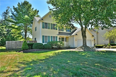Traditional-style house featuring a garage, concrete driveway, and a porch
