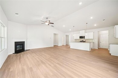 Unfurnished living room with a glass covered fireplace, light wood-style floors, vaulted ceiling, ceiling fan, and recessed lighting