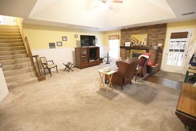 Carpeted living room with a raised ceiling, a bric