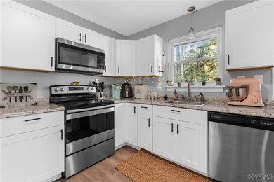 Kitchen with sink, light stone counters, appliance