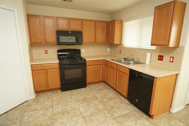 This kitchen features warm wood cabinetry, a black