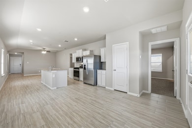 Kitchen featuring white cabinets, plenty of natural light, an island with sink, stainless steel appliances, and recessed lighting