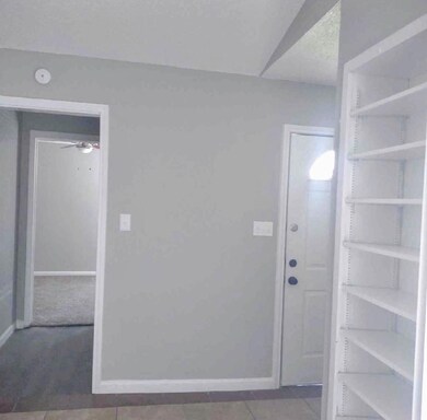 Carpeted foyer featuring baseboards and a ceiling