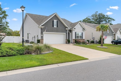 View of front facade featuring a garage, central AC, driveway, a gate, and stone siding