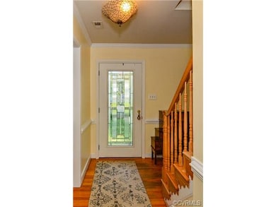 Foyer with warm hardwoods that continue up the sta