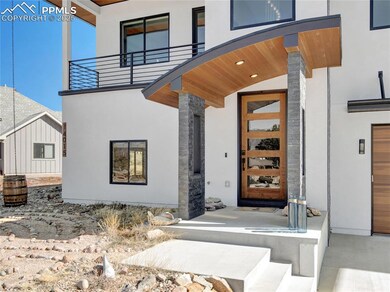View of exterior entry with a balcony and stucco siding