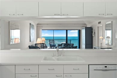 Kitchen with dishwasher, white cabinetry, light countertops, open floor plan, and a water view