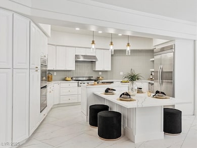 Kitchen with light marble finish floors, under cab