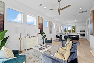 Living area with light wood-type flooring, a ceiling fan, and recessed lighting