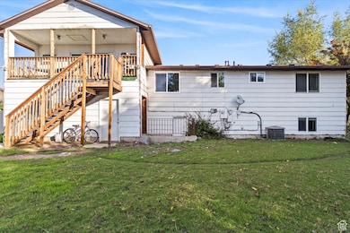 Back of property featuring a lawn and stairway