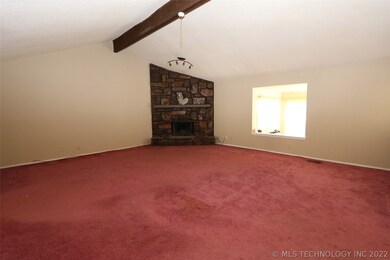 Living area with stone fireplace and vaulted ceili