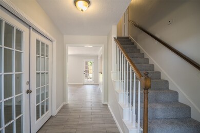 Foyer area has flex room on the left, Living room straight ahead, stairway and and formal dining on the right.