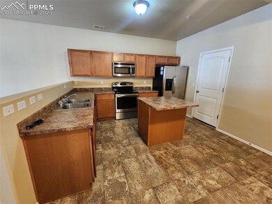 Kitchen featuring stainless steel appliances, visible vents, a sink, a kitchen island, and baseboards