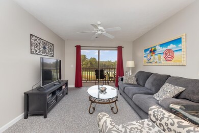 Carpeted living room with ceiling fan