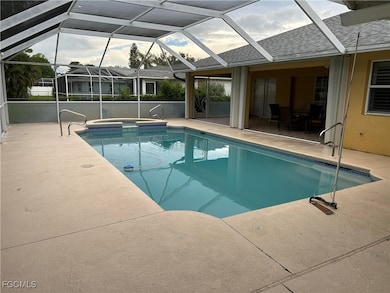 View of swimming pool with a patio, glass enclosure, a pool with connected hot tub, and a sunroom