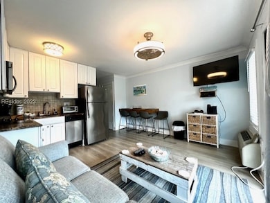 Living room with crown molding, sink, and light ha