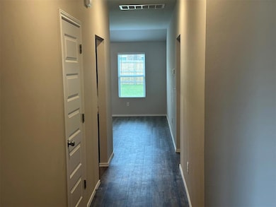 Hallway with dark wood-style flooring and baseboards