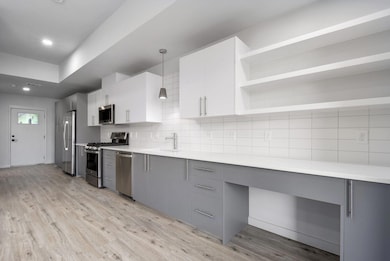 Kitchen with stainless steel appliances, gray cab